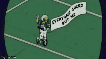 a cartoon of a football player holding a sign that says `` everyone sucks but me '' on a football field .