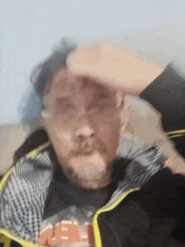 a man with a beard wearing a black shirt that says ' uee ' on it