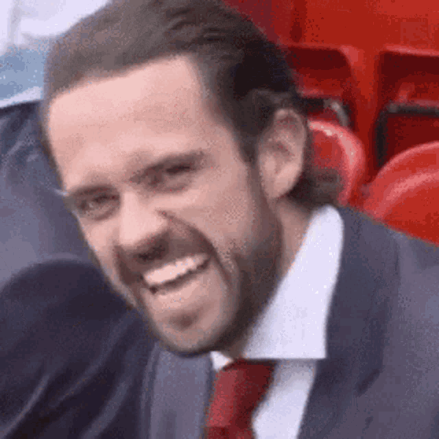 a man in a suit and tie is making a funny face .