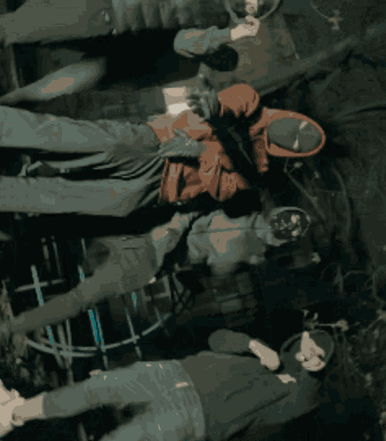 a group of people are laying on their backs and one of them is wearing a red hoodie