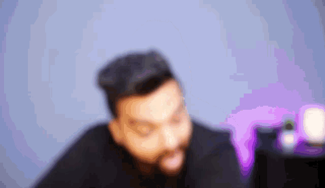 a blurry picture of a man with a beard making a face