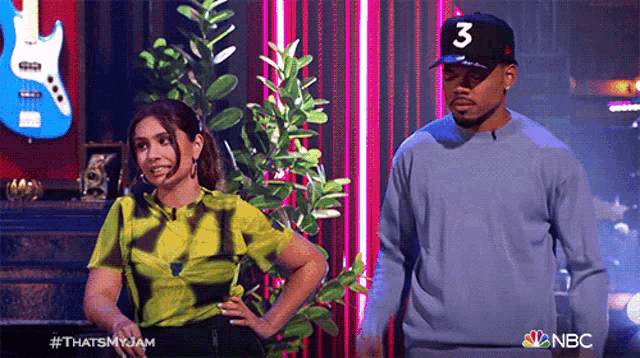 a man wearing a hat with the number 3 on it is standing next to a woman