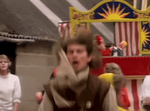 a man is standing in front of a carnival display with a sun on it