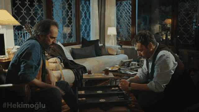 two men are playing a game in a living room with the hashtag #hekimoglu