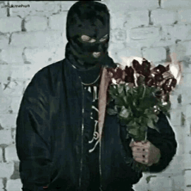 a man wearing a ski mask is holding a bouquet of flowers