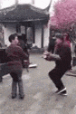a group of people are dancing in a park in front of a pagoda .