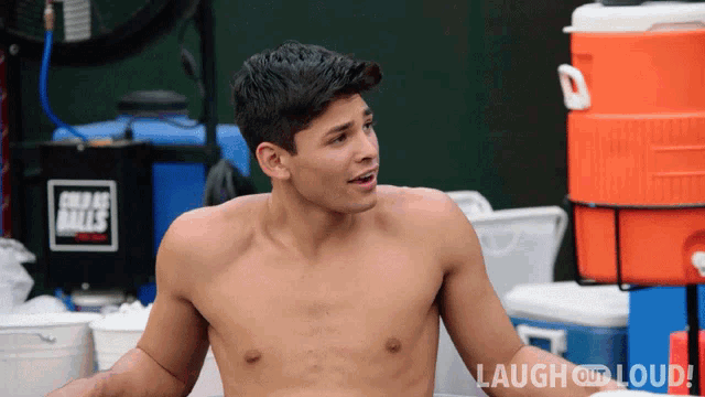 a shirtless man is sitting in front of a laugh out loud sign