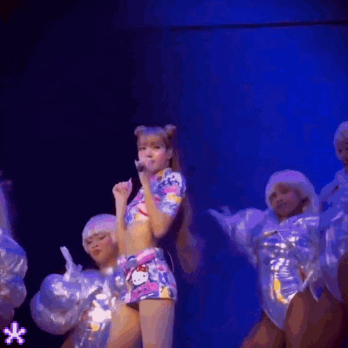 a woman in a hello kitty outfit is singing into a microphone on stage .
