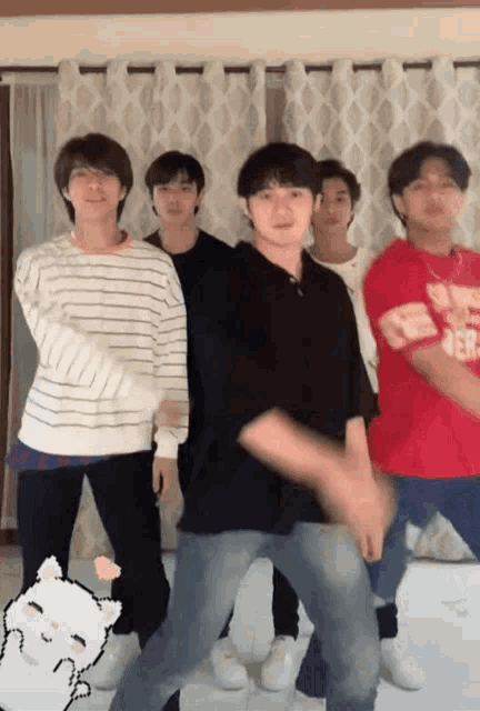 a group of young men are standing next to each other dancing in a room .