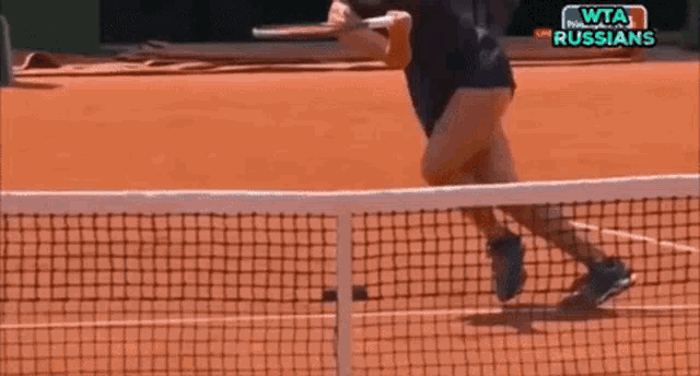 a woman is playing tennis on a court with the words wta russians on the screen behind her
