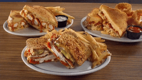three plates of food including sandwiches and french fries