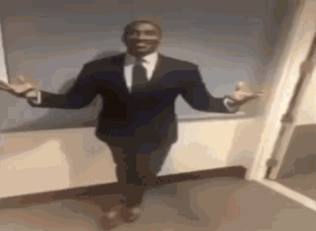 a man in a suit and tie is dancing with his arms outstretched .