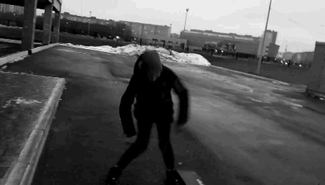 a black and white photo of a person riding a skateboard on a street