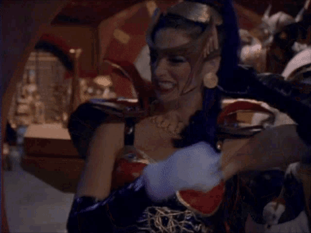 a woman in a costume with a purple ponytail holds a sword