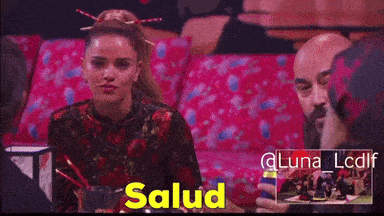 a woman sitting next to a man with the word salud on the bottom right