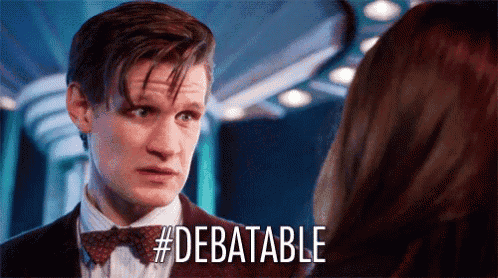 a man in a suit and bow tie is talking to a woman and the word debatable is visible