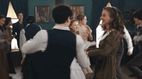 a group of people are dancing in a room with paintings on the walls