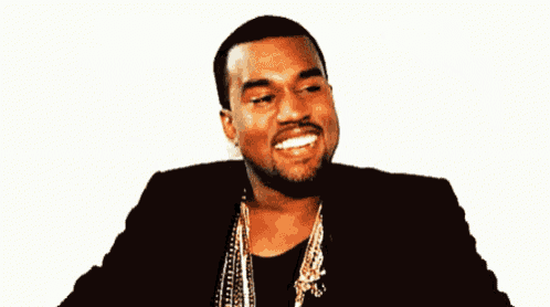 a man with a beard is wearing a black jacket and gold chains .