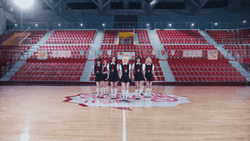 a group of girls are standing on a basketball court with the letter s on the floor