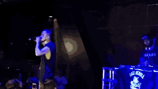 a man singing into a microphone while wearing a shirt that says ' all eagle ' on it