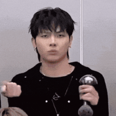 a young man is making a funny face while holding a dumbbell in his hand .