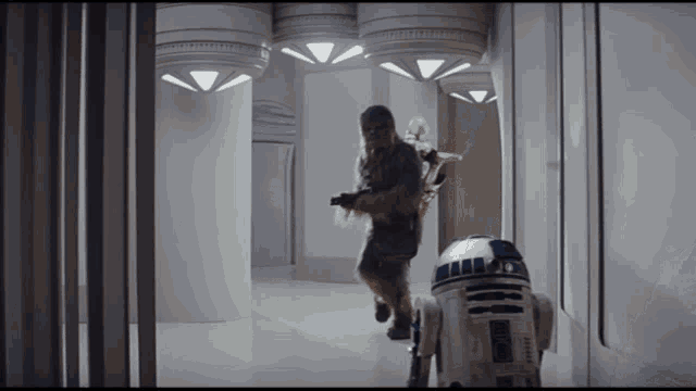 chewbacca and r2d2 are running through a hallway in a star wars scene