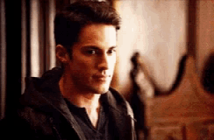 a close up of a man wearing a black jacket and a black shirt