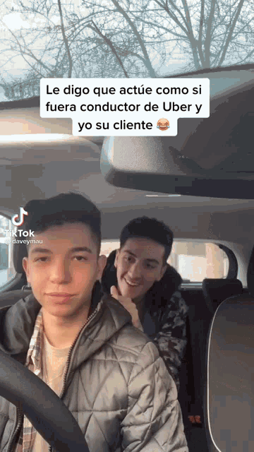 two young men are sitting in a car and one of them has a tiktok sticker on his face