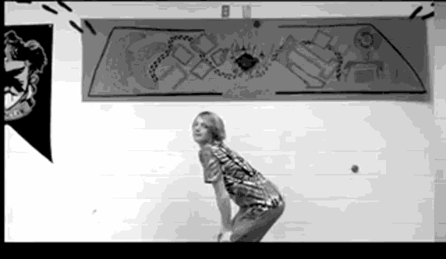a black and white photo of a girl standing in front of a harry potter banner