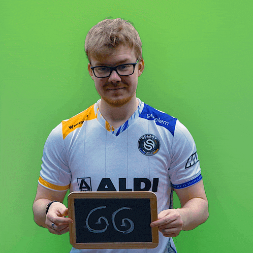 a man holding a chalkboard with the number gg on it