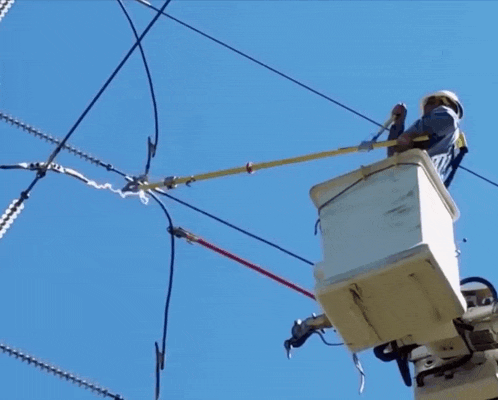 a man in a bucket on top of a power line