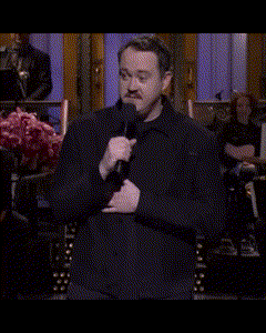 a man in a black jacket holds a microphone in his hand