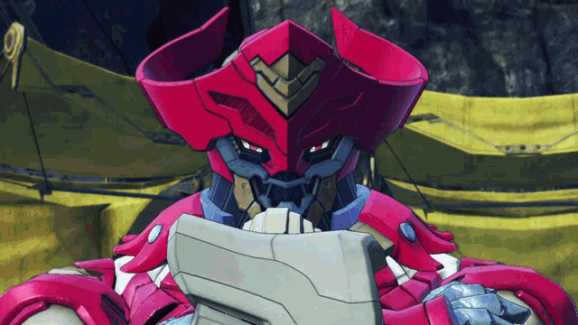 a red robot is holding a piece of paper in front of his face