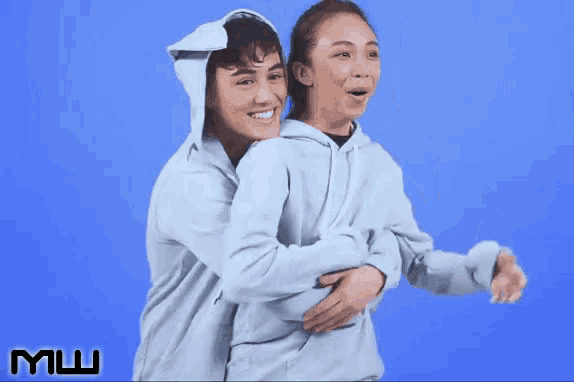 a man and a woman hugging each other with a blue background and the letters mw on it