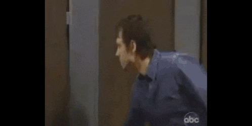 a woman is standing in front of a man in a doorway .