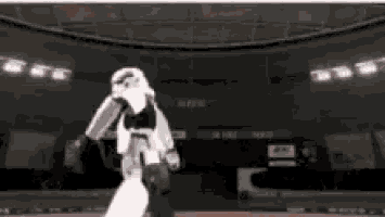 a storm trooper is standing in a stadium with a basketball in his hand .