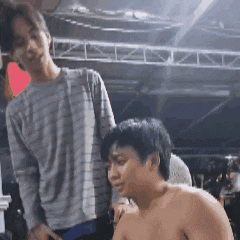 a man without a shirt is standing next to another man .