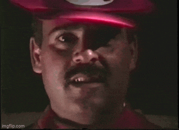 a man with a mustache wearing a red hat with a m on it