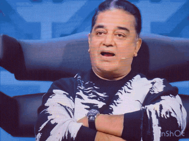 a man with his arms crossed is wearing a black and white sweater that says inshot