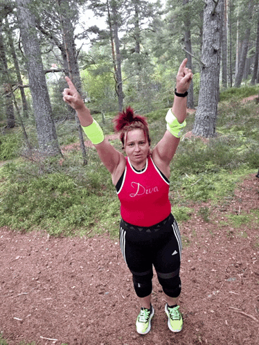 a woman in a diva shirt stands in a forest
