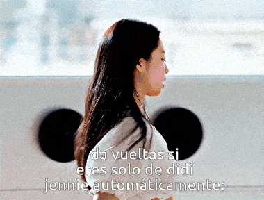 a woman is standing in front of a window with the words da vueltas si eres solo de didi jennie automaticamente written below