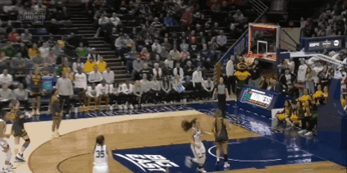 a basketball game is being played in front of a crowd with espn on the wall