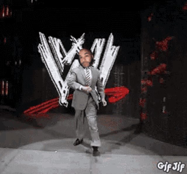 a man in a suit and tie is dancing on a stage in front of a w logo