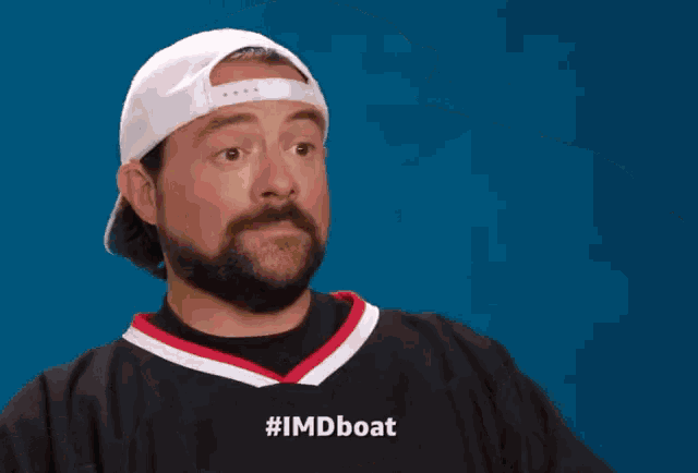 a man with a beard wearing a hat and a shirt that says #imdboat