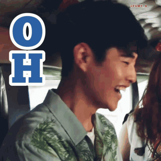 a man in a green shirt is smiling with a sticker that says oh on it