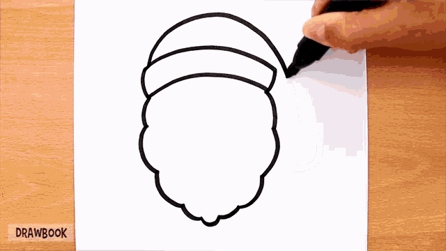 a person is drawing a santa claus head with a marker on a piece of paper