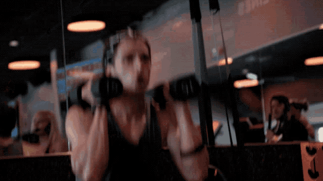 a person lifting dumbbells in front of a sign that says ' e3m2 ' on it