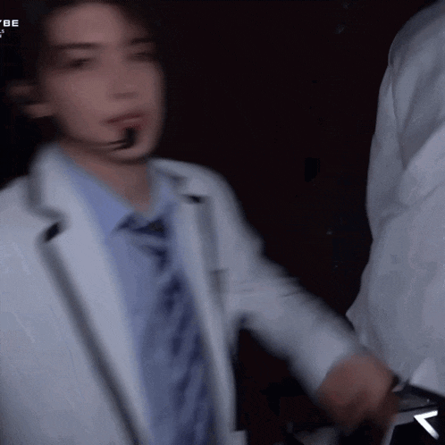 a blurry picture of a man wearing a white jacket and tie