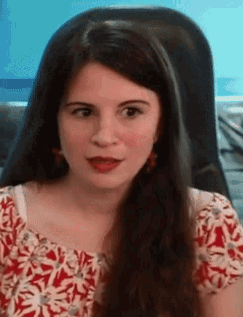 a woman with long hair is wearing a red and white shirt