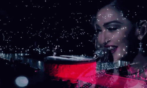 a woman is singing into a microphone while playing a red piano .